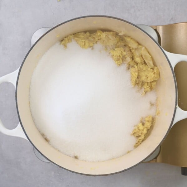 Adding sugar to the ginger-lemon mix.