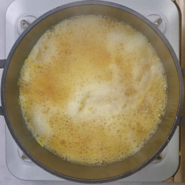 Lemon peel boiling in a small saucepan.