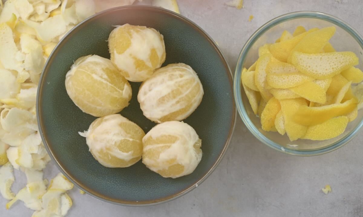 Peeled lemons in a bowl, with the peel in another bowl, and the pith on the side.