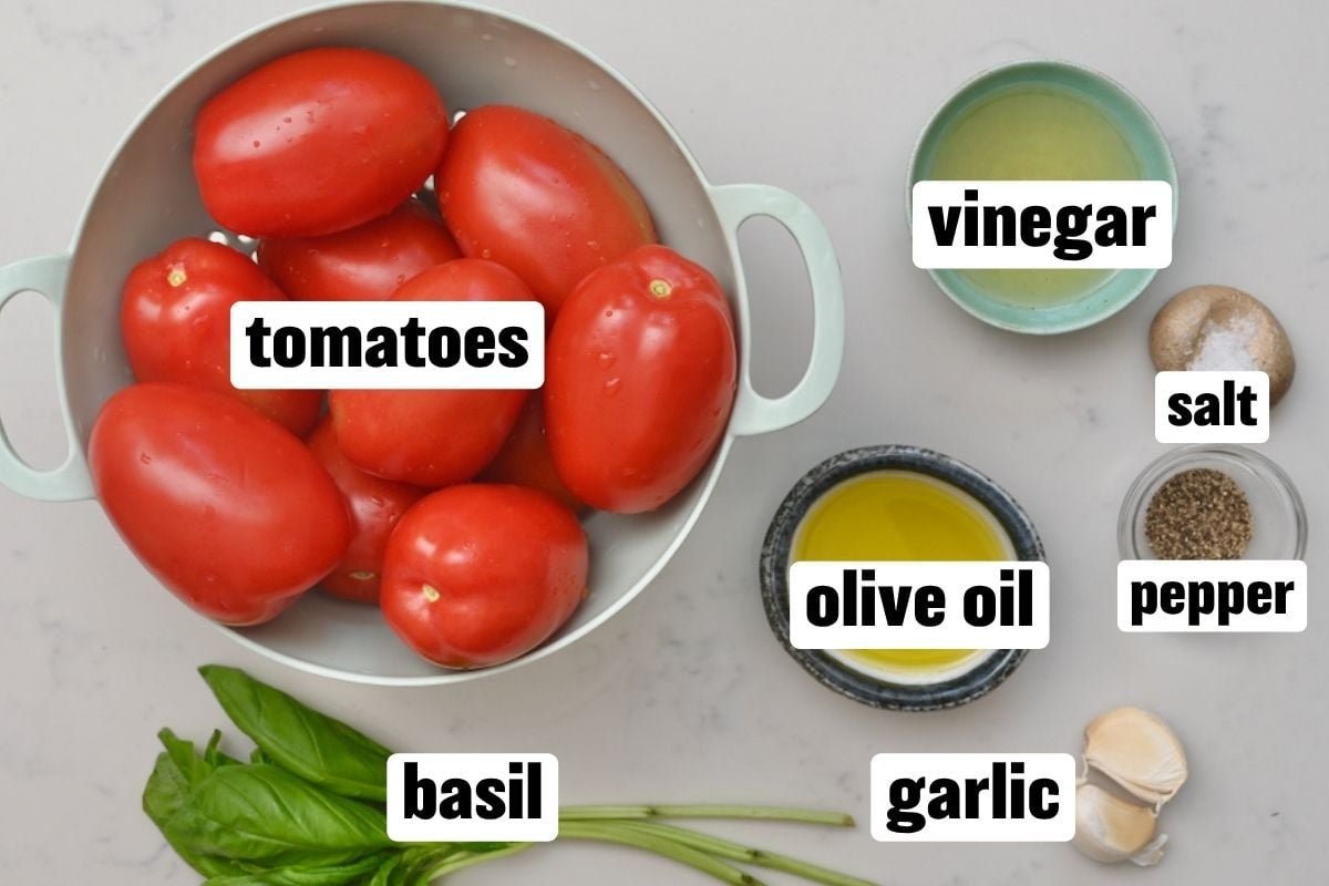 Flat lay layout of simple tomato salad ingredients labeled with text.