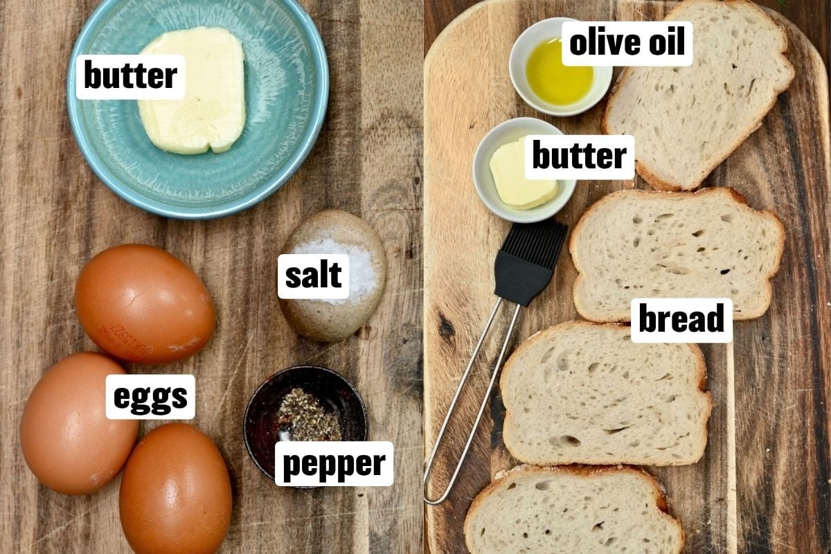 An ingredient flat lay arranged on a rustic wooden surface featuring whole brown eggs, butter in a blue ceramic dish, salt, crushed black pepper, olive oil in a small bowl, slices of white bread on a cutting board, and a silicone pastry brush.